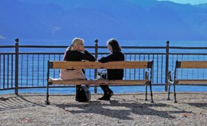 The healing power of listening. Two people sitting on at outdoor bench.