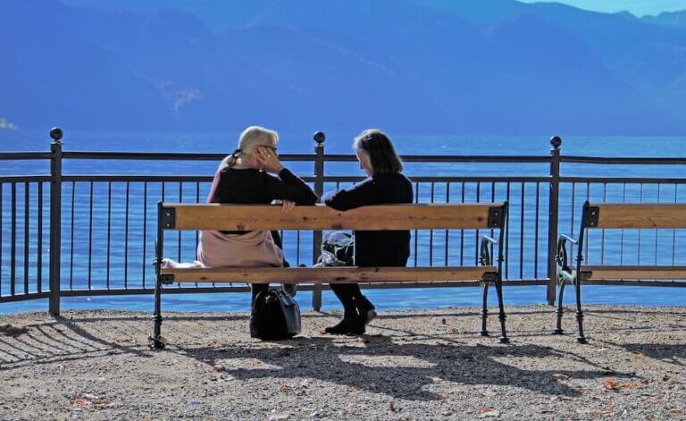 The healing power of listening. Two people sitting on at outdoor bench.